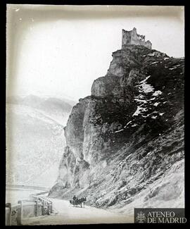 
Montaña con castillo y hombre conduciendo un carro de caballos
