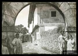 Niños delante del arco que da entrada a una casa rural