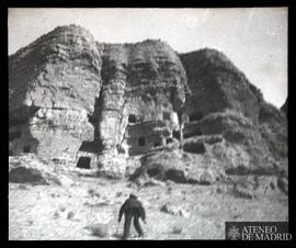 Montañas con cuevas y hombre en primer plano