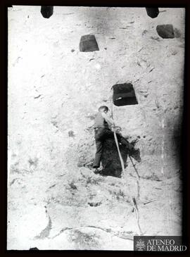 Hombre escalando por las cuevas de una montaña